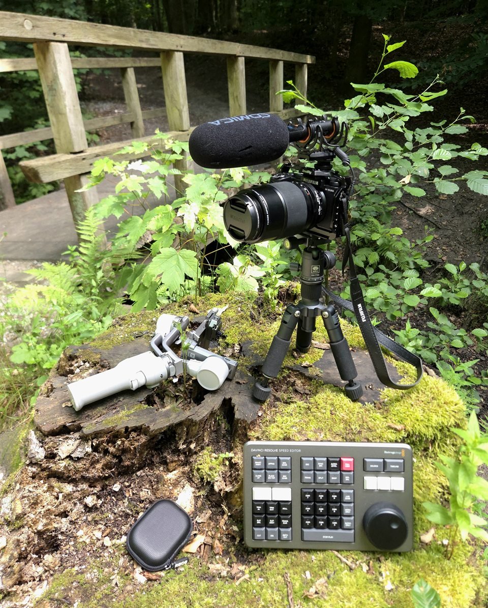 Fujifilm camera with a COMICA microphone on a compact tripod, alongside a DJI gimbal and DaVinci Resolve Speed Editor